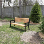 a recycled plastic memorial garden and park bench in the backyard