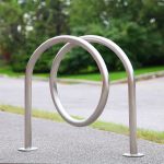 stainless steel bike commercial parking rack is on the pedestrian area in a community park