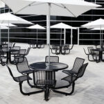 Metal patio outdoor tables with patio umbrellas create a place for employees and customers to relax and share some time and food together
