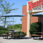 outdoor picnic table for patio with patio umbrellas are chosen by Wendy's to provide a space for their customers to enjoy their food in the open air