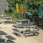 10 square outdoor recycled plastic patio tables are in service at the community center for outdoor dining