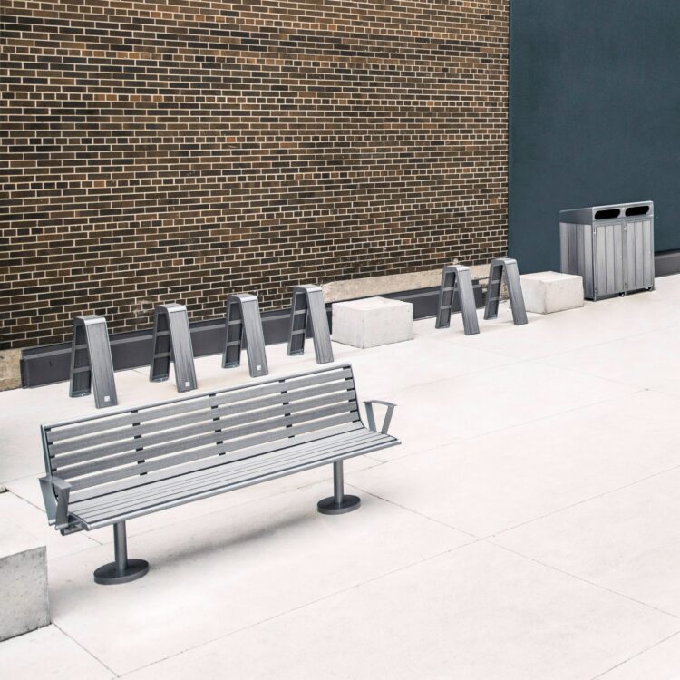 recycled plastic outdoor commercial furniture including benches, recycling stations, and bike racks installed outside an office building