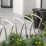 5 contemporary designed city bike securing racks are installed with our classic metal trash bin CAY-119 in the financial district in Toronto