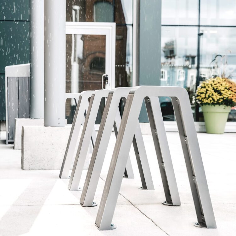 5 recycled plastic commercial bike securing rack are installed outside a office building in the Greater Toronto Area