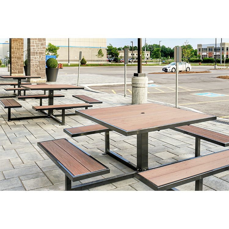 3 square park picnic dining tables are constructed with recycled plastic lumbers and metal frames on the sidewalks next to the office parking lot