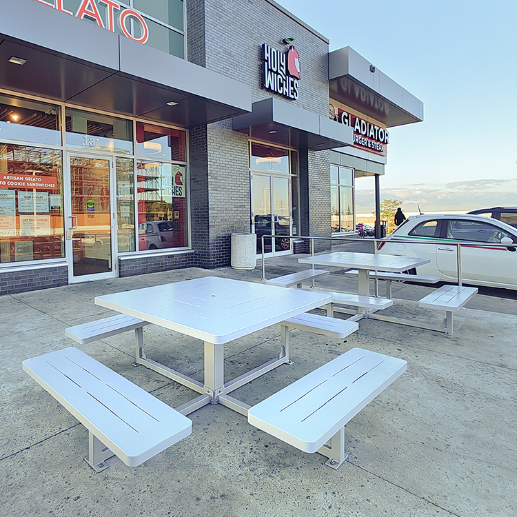 3 metal dining picnic tables are serving in the patio area of Holey Wecnes